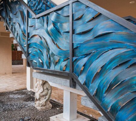 Blue abstract wave design on a glass railing indoors.