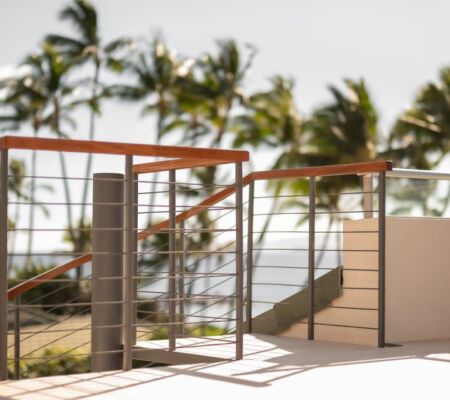 Modern balcony railing with tropical palm trees in the background.