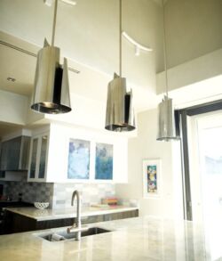 Modern kitchen with three pendant lights and a sleek countertop.