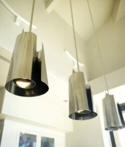 Three chrome cylinder pendants over living area