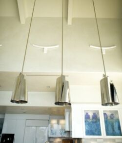 Three modern pendant lights with metallic shades hanging from the ceiling.