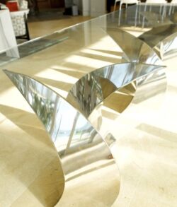 Modern curved glass table reflecting light.