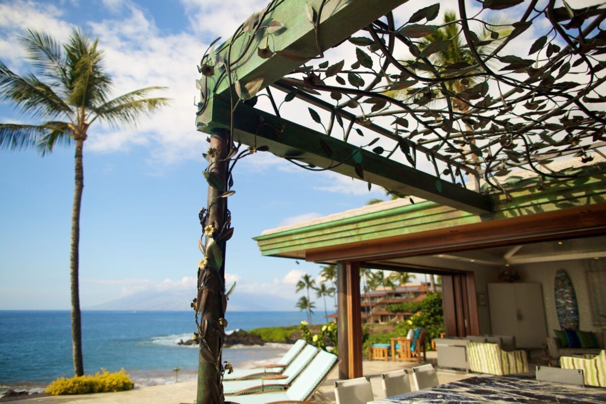 Elegant outdoor patio with ocean view and decorative pergola.