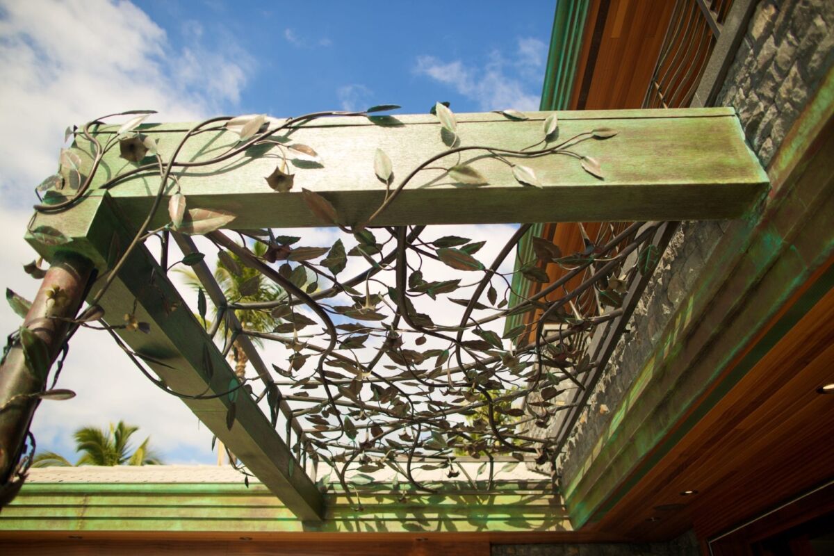 Decorative metalwork on a wooden pergola ceiling.