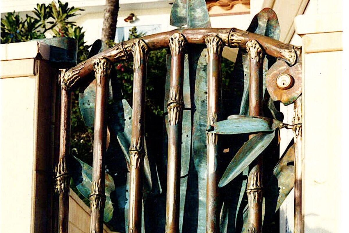 Rustic wooden gate with a sturdy latch in a sunny outdoor setting.