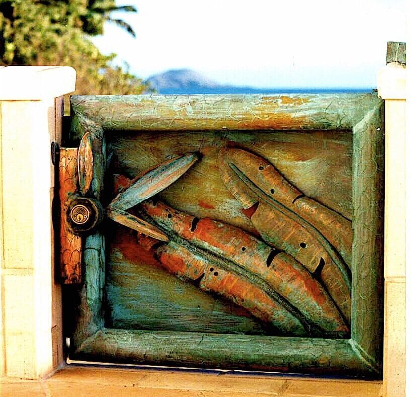 Wooden fish sculptures framed in a rustic box.