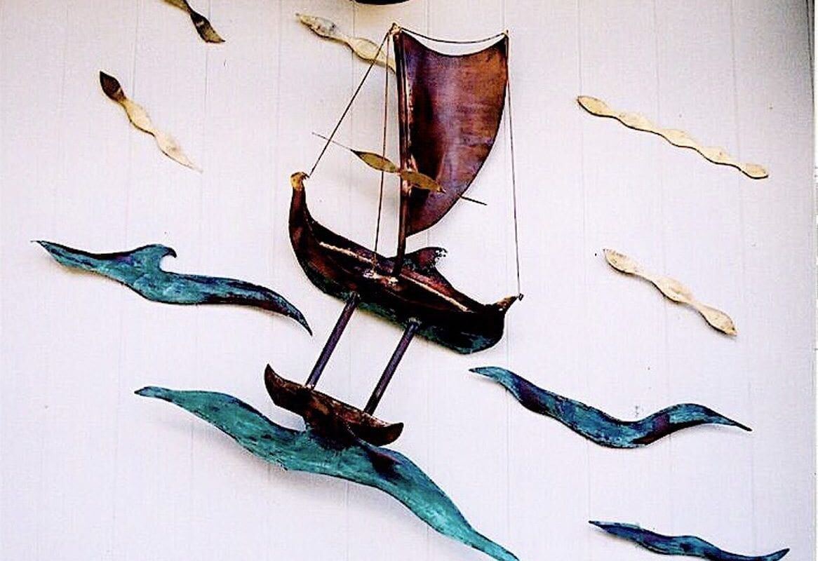 Artistic mobile of a Viking ship with sails and oars.