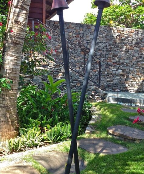 Artistic metal sculpture with intertwined curved rods outdoors.