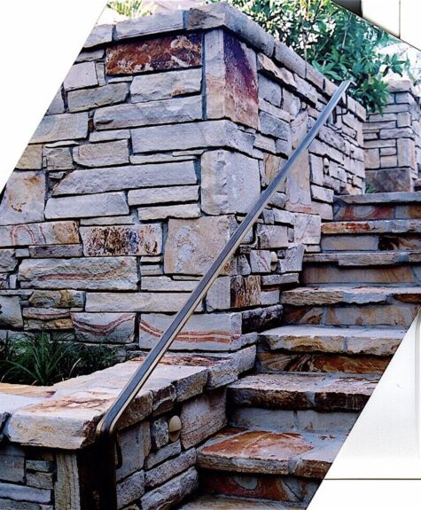 Stone staircase with metal handrail and stone wall.
