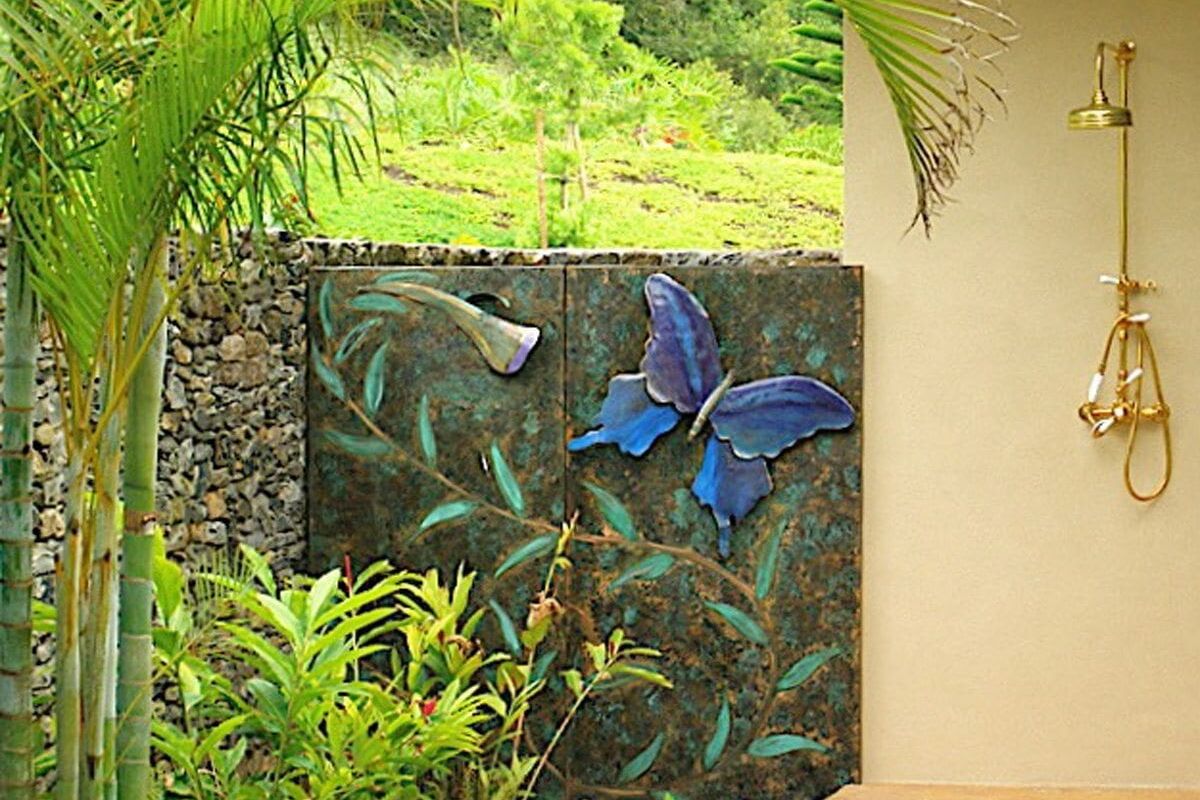 Decorative butterfly wall art in a garden setting.