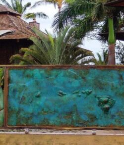 Decorative wall with bird sculptures and tropical plants behind it.