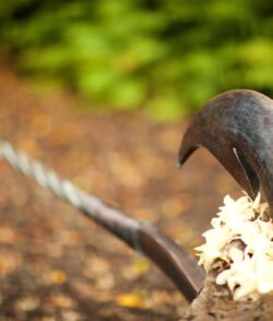 Close Up of the Brand-New Copper Fish Hook Close-up of rusty iron hook on a chain outdoors.