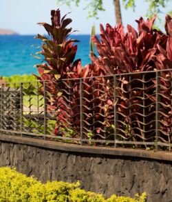 Waves crashing against a rocky shoreline under a blue sky.