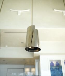 Modern pendant lights hanging from a white ceiling in a minimalist room.