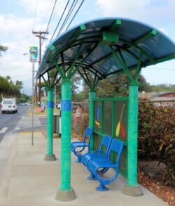 Colorful bus stop shelter with blue benches and green pillars.