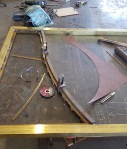 Metalworking project with tools and metal pieces on a workbench.