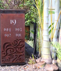 Decorative wooden sign with years and bamboo stalks beside it.