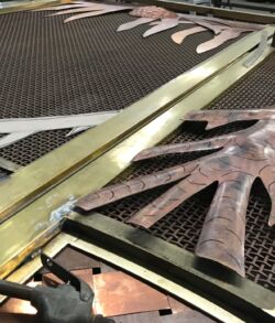 Positioning the base of the Hala tree Close-up of an ornate clock face with Roman numerals and golden hands.