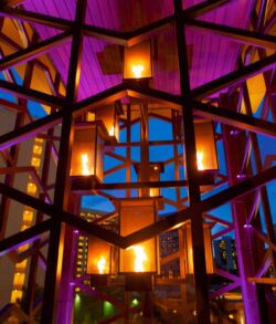 Close up view of our copper fire tower Modern chandelier with warm lights and purple accents in a stylish interior.