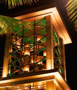 Outside view of our 68ft copper fire tower located on Oahu Modern building facade illuminated with warm lighting at night.