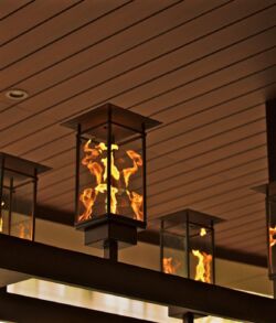Close up view of stainless steel fire chandelier Decorative lanterns with warm lights hanging from a ceiling.
