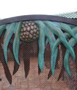 Close-up of a green, tentacle-like sculpture with a spiky ball at the center.