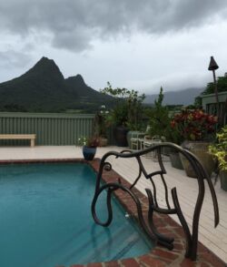 Our creative side reveals a copper sculpted elephant design named "Ubuntu" Poolside view with mountainous backdrop under cloudy sky.