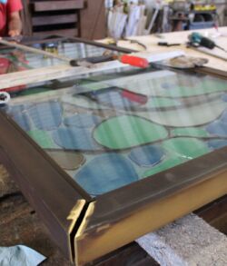 Handcrafting a stained glass panel with intricate geometric patterns.