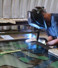 A person welding metal in a workshop.