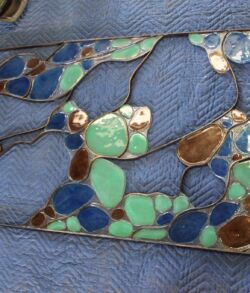 Close-up of a textured blue surface with colorful mosaic pieces.