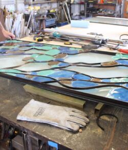 A stained glass artwork in progress on a workbench.