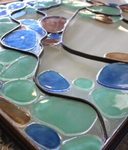Close-up of colorful stained glass with blue and green pieces.