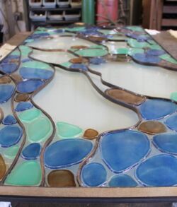 Close-up of a colorful stained glass panel with blue and green pieces.