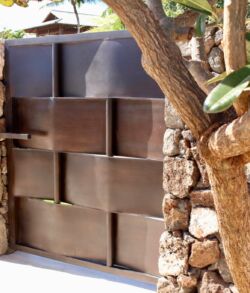 Interior view of pedestrian entry gate Stacked black boxes arranged in a stone-framed outdoor setting.