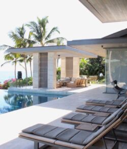 Ocean front view of Lanai estate Modern poolside lounge area with ocean view and palm trees.