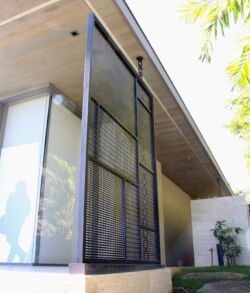 Modern house entrance with large glass and metal door.