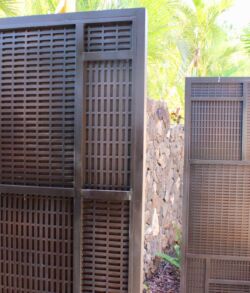Two brown wooden lattice panels standing outdoors.