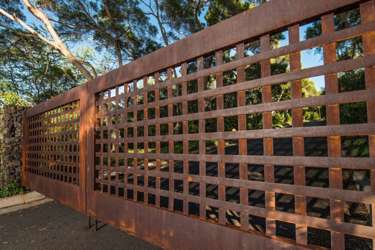 Rusty metal gate with square grid pattern outdoors.