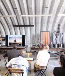 People attending a presentation in a modern, industrial-style room.