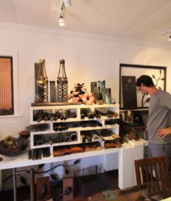 Man observing a display of bottles and items in a well-lit room.