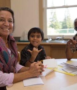 A happy family spending time together at a table with papers.