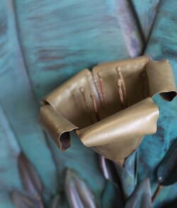 A close-up of a torn, brown paper bag on a blue surface.