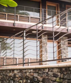 Modern staircase with wooden steps and metal railing outside a building.