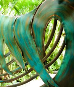 Close-up of a greenish-blue metal sculpture with curved, rib-like structures.