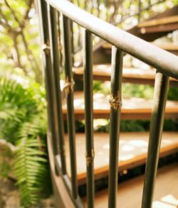 Close-up of a modern metal and wood spiral staircase railing.