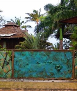 Padilla Designs artist used a combination of brush and sponge application techniques to bring out specific color tones for this masterpiece of an island paradise. Rustic outdoor seating area with a thatched roof and tropical plants.