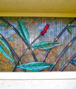 Wall art featuring colorful metal leaves on a textured background.