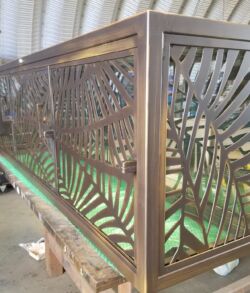 Intricately designed metal railing with geometric patterns and a bronze finish.