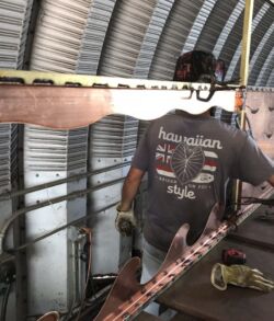 A person working on a project inside a metal shed.