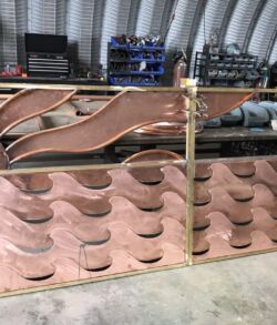 Stacks of copper roofing tiles in a warehouse.